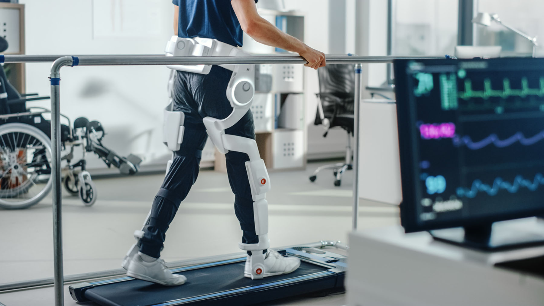Modern Hospital Physical Therapy: Patient with Injury Walks on Treadmill Wearing Advanced Robotic Exoskeleton Legs. Physiotherapy Rehabilitation Technology to Make Disabled Person Walk. Focus on Legs medical battery innovation by ultralife